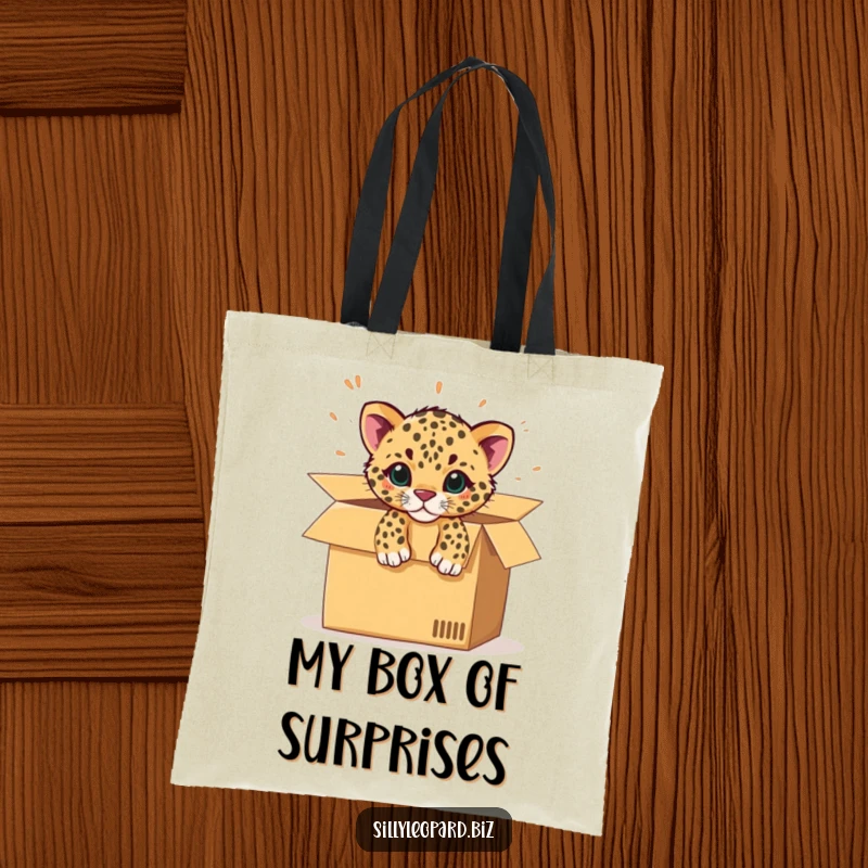Funny tote bag showing a spotted leopard cub bursting from an office cardboard box, perfect for carrying items with flair.